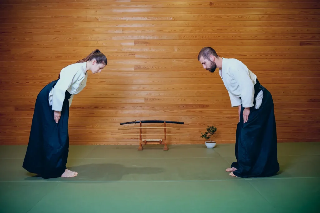 İki aikidoka ayakta karşılıklı eğilerek selamlaşıyor, Katsu Ankara, Çayyolu.