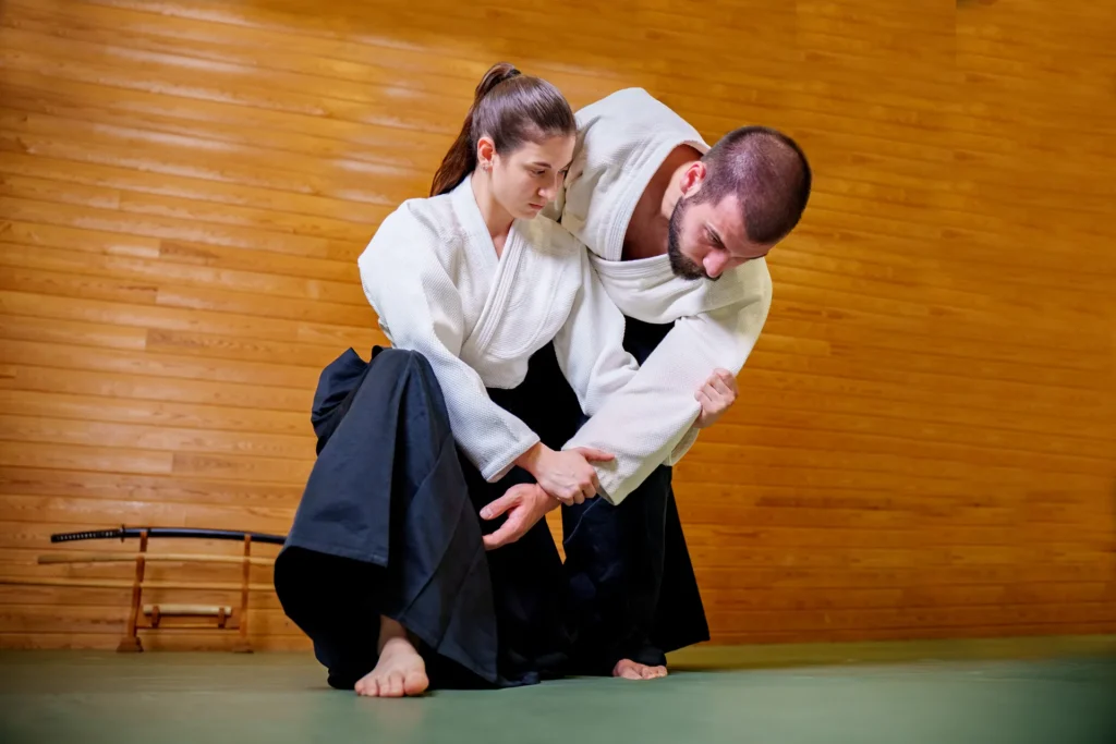Yakın plan aikido tekniği, hakamalı iki aikidoka ahşap duvar önünde, Katsu Ankara, Çayyolu.