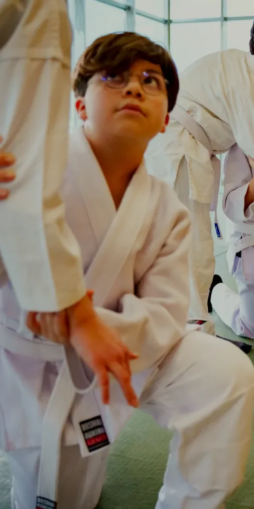 Çocuk aikido dersinde keikogili bir öğrenci dikkatle dinliyor, Katsu Ankara, Çayyolu.