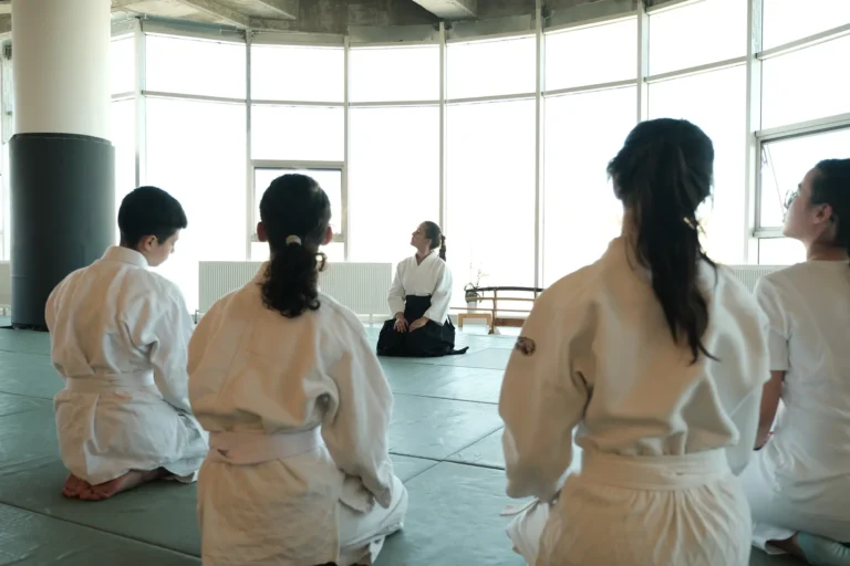 Genç aikido grubu tatamide diz üstü oturmuş, eğitmenini dinliyor, Katsu Ankara, Çayyolu.