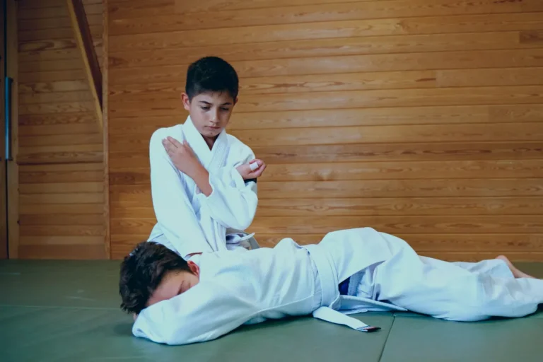 Genç aikido öğrencisi ahşap duvar önünde partnerini minderde sabitliyor, Katsu Ankara, Çayyolu.