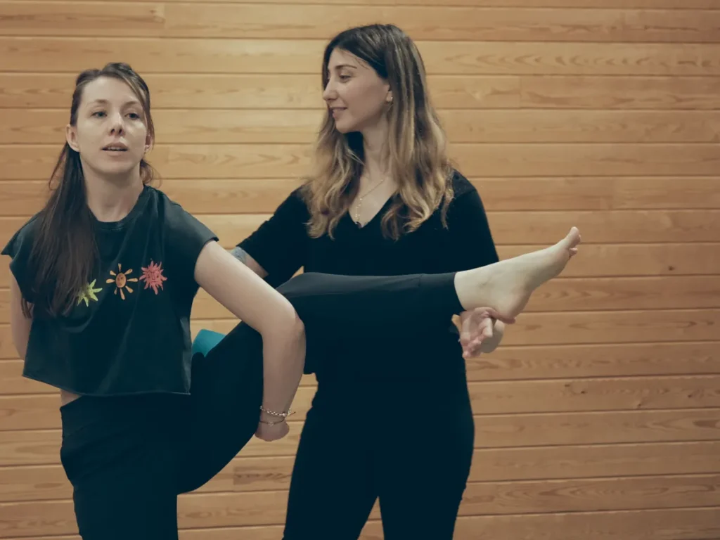 Yoga dersinde eğitmen bir öğrencinin bacak esnemesine yardım ediyor, Katsu Ankara, Çayyolu.